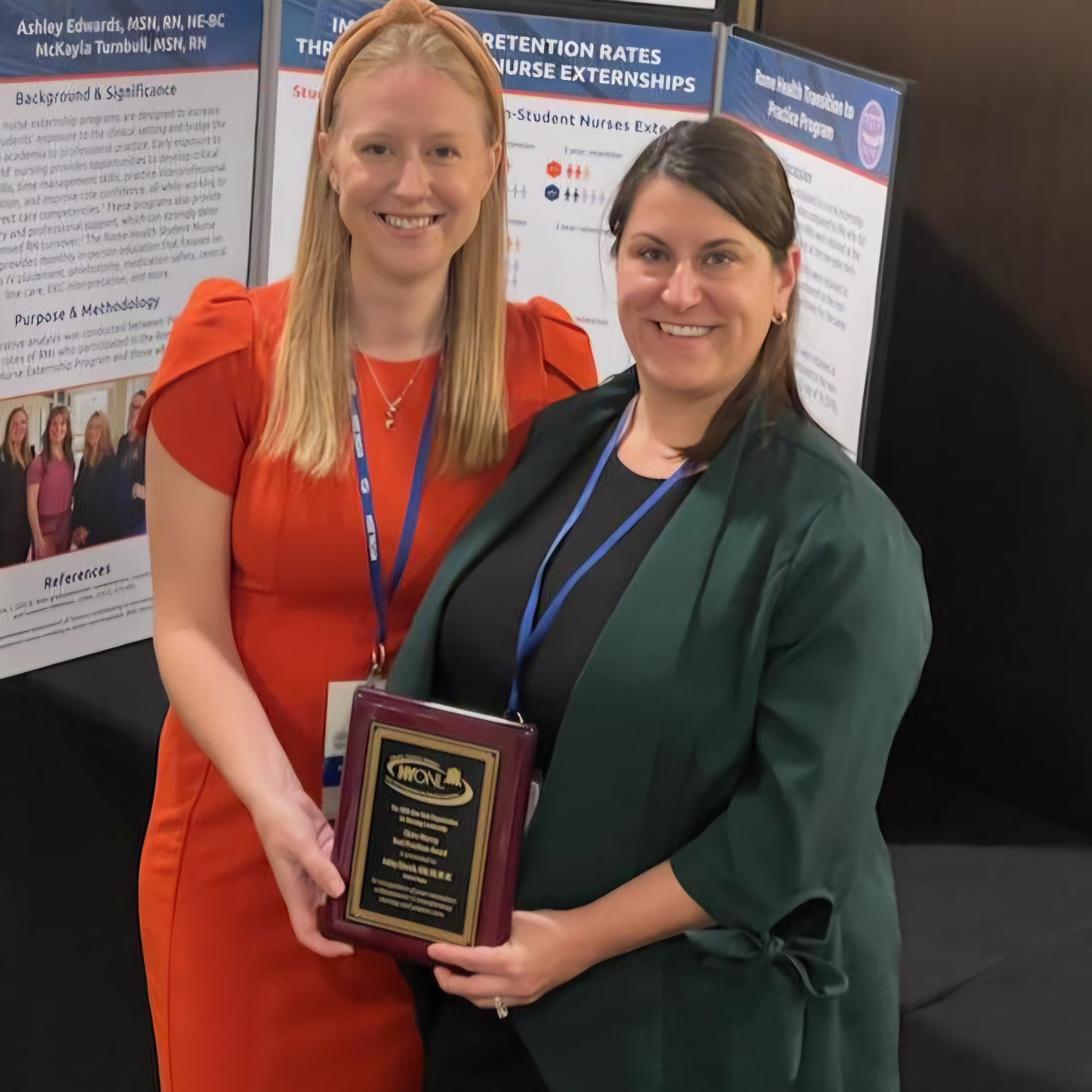 Picture of Chief Nursing Officer/VP Clinical Services Ashley Edwards, MSN, RN, NE-BC and Transitions to Practice and Extern Program Director McKayla Turnbull MSN, RN, standing with the Claire Murray Best Practices Award.